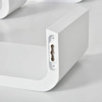 Close-up of white floating shelf bracket with hidden mounting hardware.