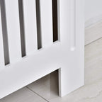 White radiator cover leg and slatted grille detail with open airflow gaps