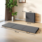 Grey tri-fold workout mat with visible carrying handles, laid open on the floor