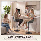 Two grey bar stools with swivel bases, padded seats, curved backrests, and armrests