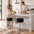 Two black swivel bar stools with round padded seats and chrome bases