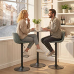 Two green swivel bar stools with footrests shown in a bright kitchen dining setting