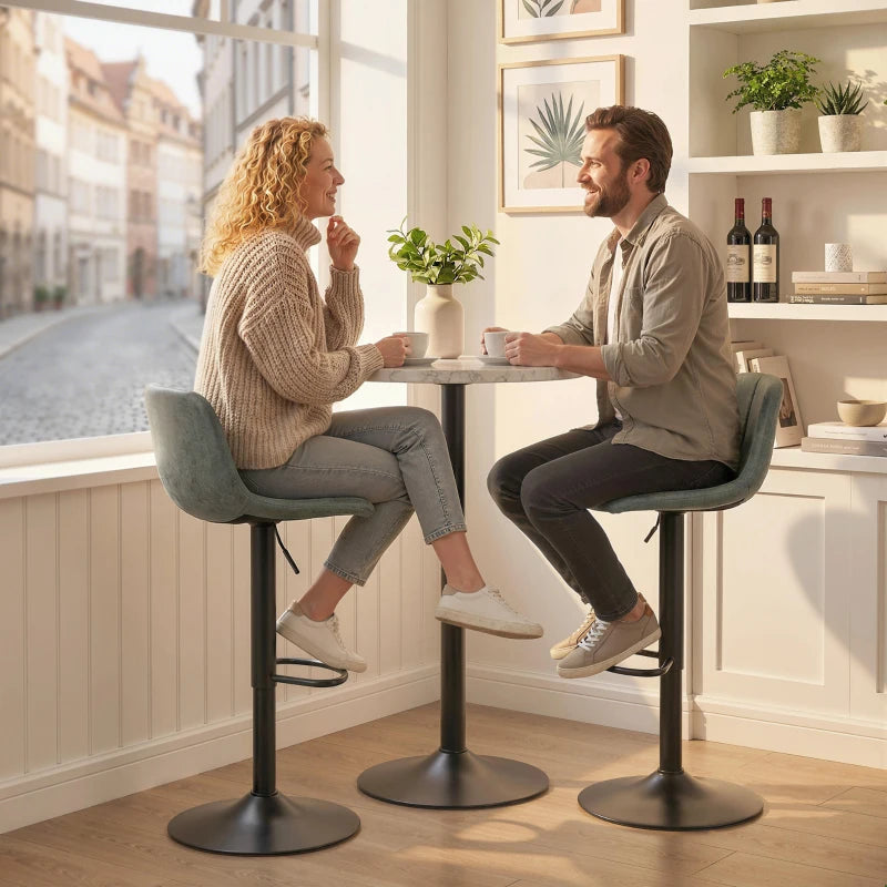 Two green swivel bar stools with footrests shown in a bright kitchen dining setting
