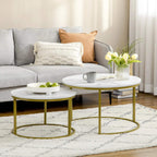 Two round nesting tables with white marble-look tops and gold metal frames