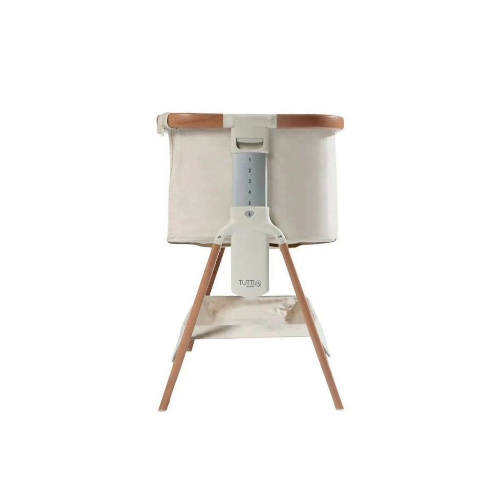 White support bracket under canopy on ecru bedside crib with walnut legs