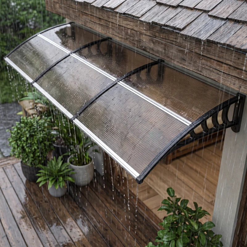 Brown outdoor door canopy with mesh roof and arched support arms, shown in rain