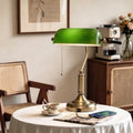 Green glass desk lamp with bronze base and pull-cord chain on stem