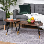 Two walnut round coffee tables with black legs and gold accents in living room