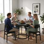 Round black dining table with conical metal base for family meals