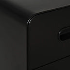 Close-up of black file cabinet drawer front with curved handle opening