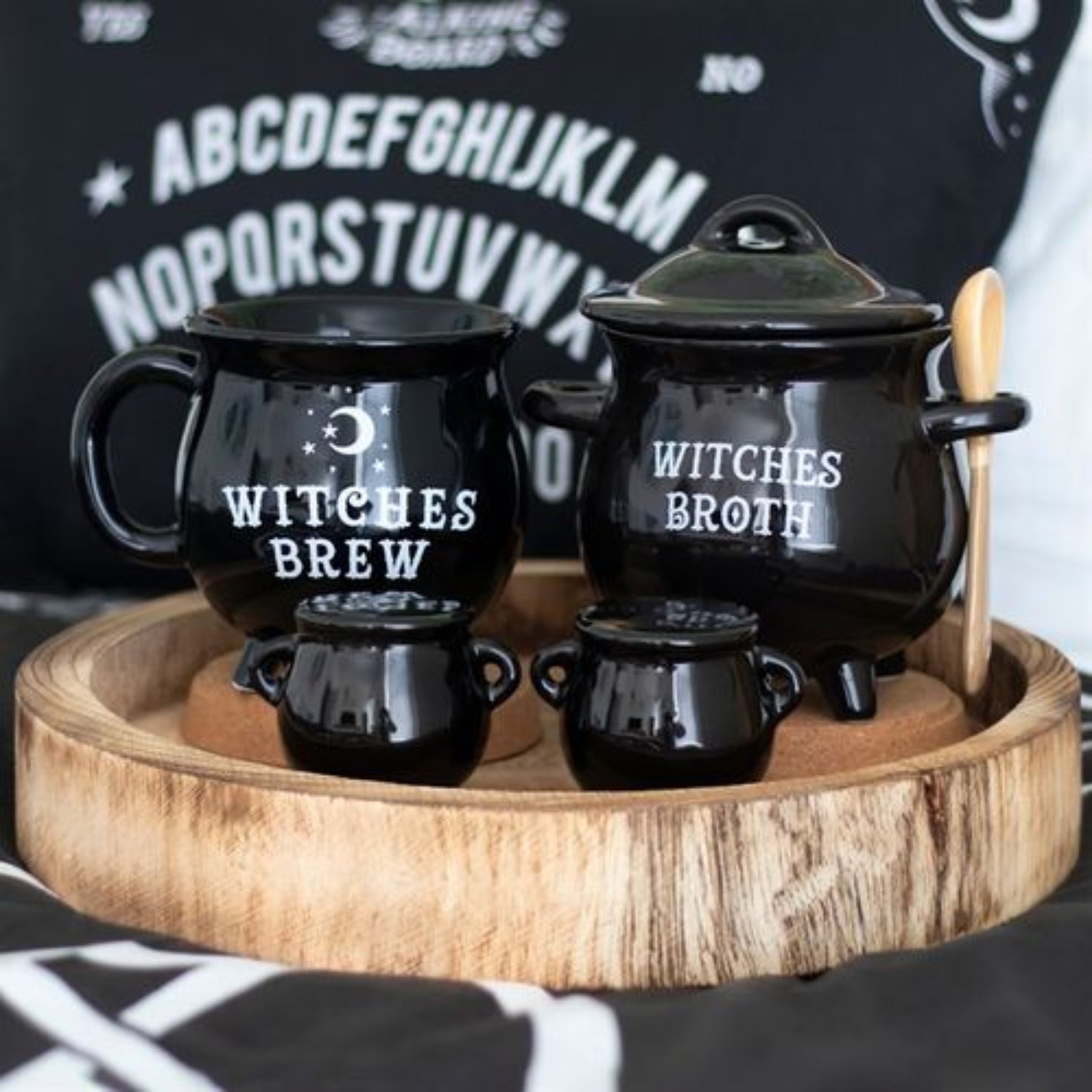 Black ceramic pots with 'Witches Brew' and 'Witches Broth' text on a wooden tray.