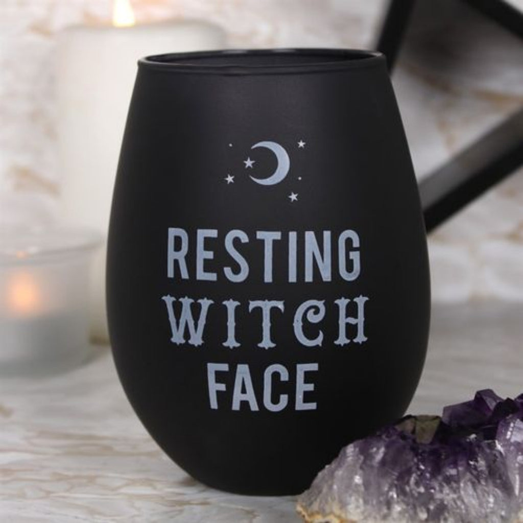 Black wine tumbler with 'Resting Witch Face' text on a surface with candles and crystals.