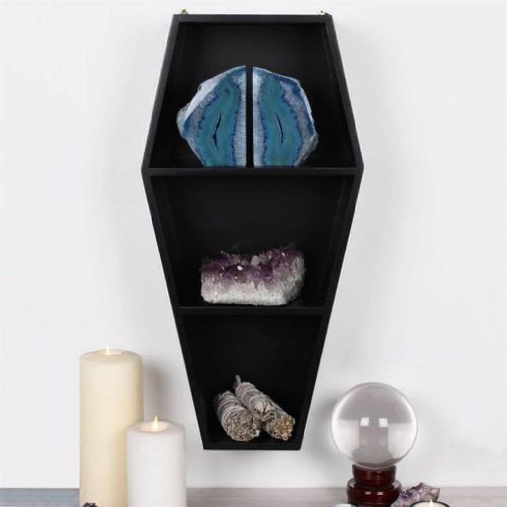 Black hexagonal shelf with decorative items on a white background