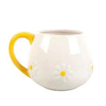 Rounded ceramic mug with daisy embossing and yellow handle