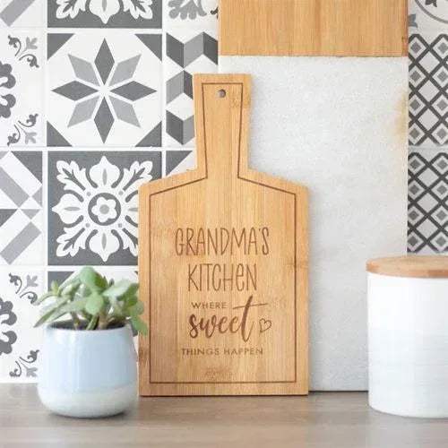 Bamboo serving board upright with engraved “Grandma’s Kitchen Sweet” text.