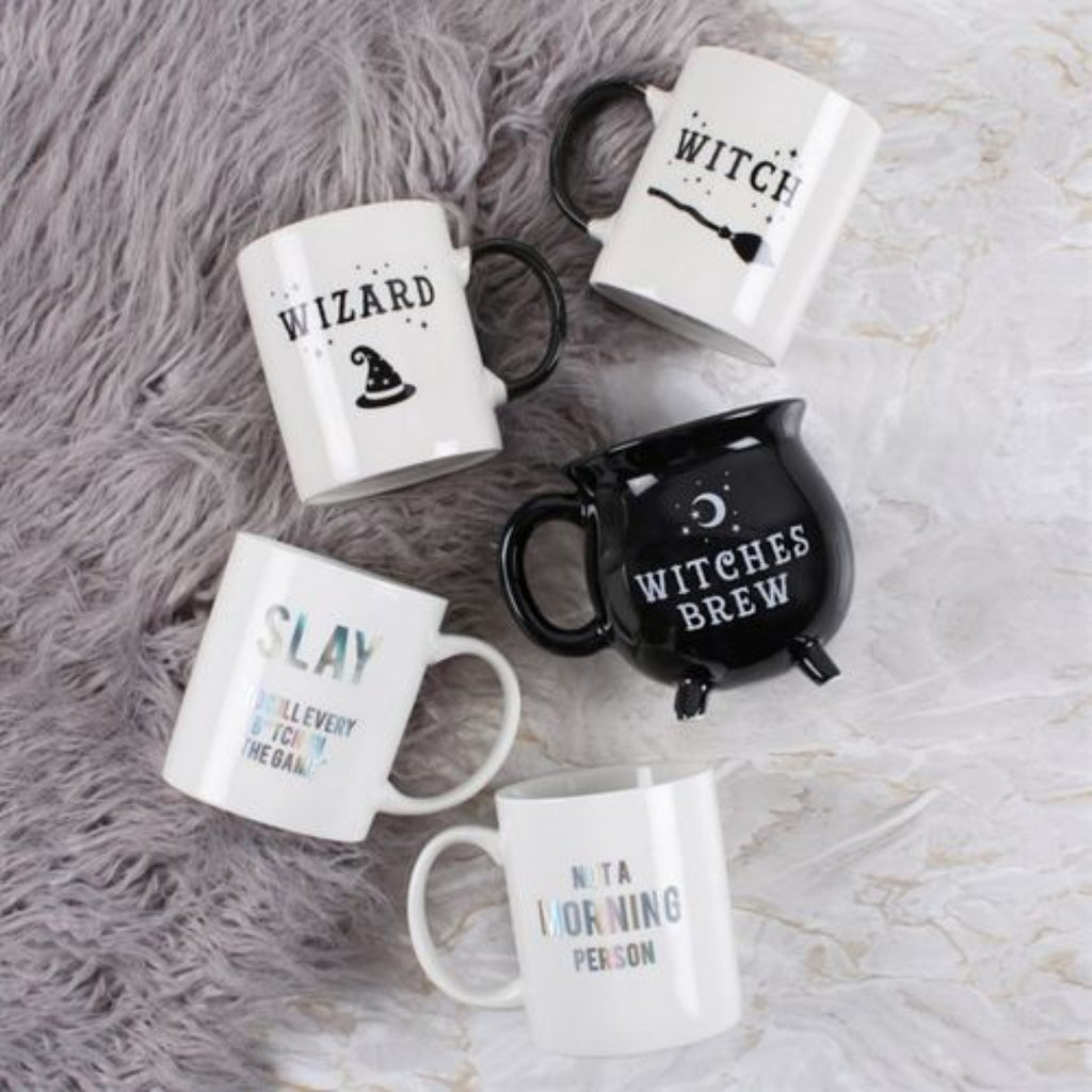Set of mugs with Halloween-themed text and designs on a textured surface.