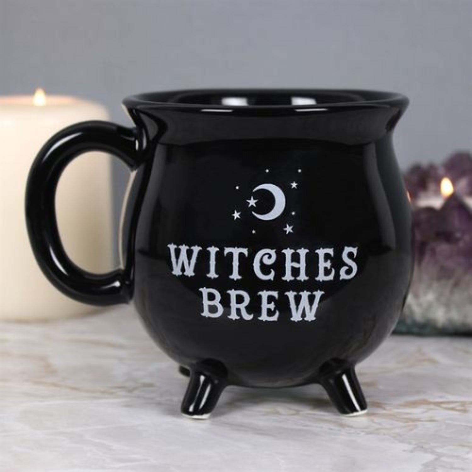 Black mug with 'Witches Brew' text and moon design on a neutral background