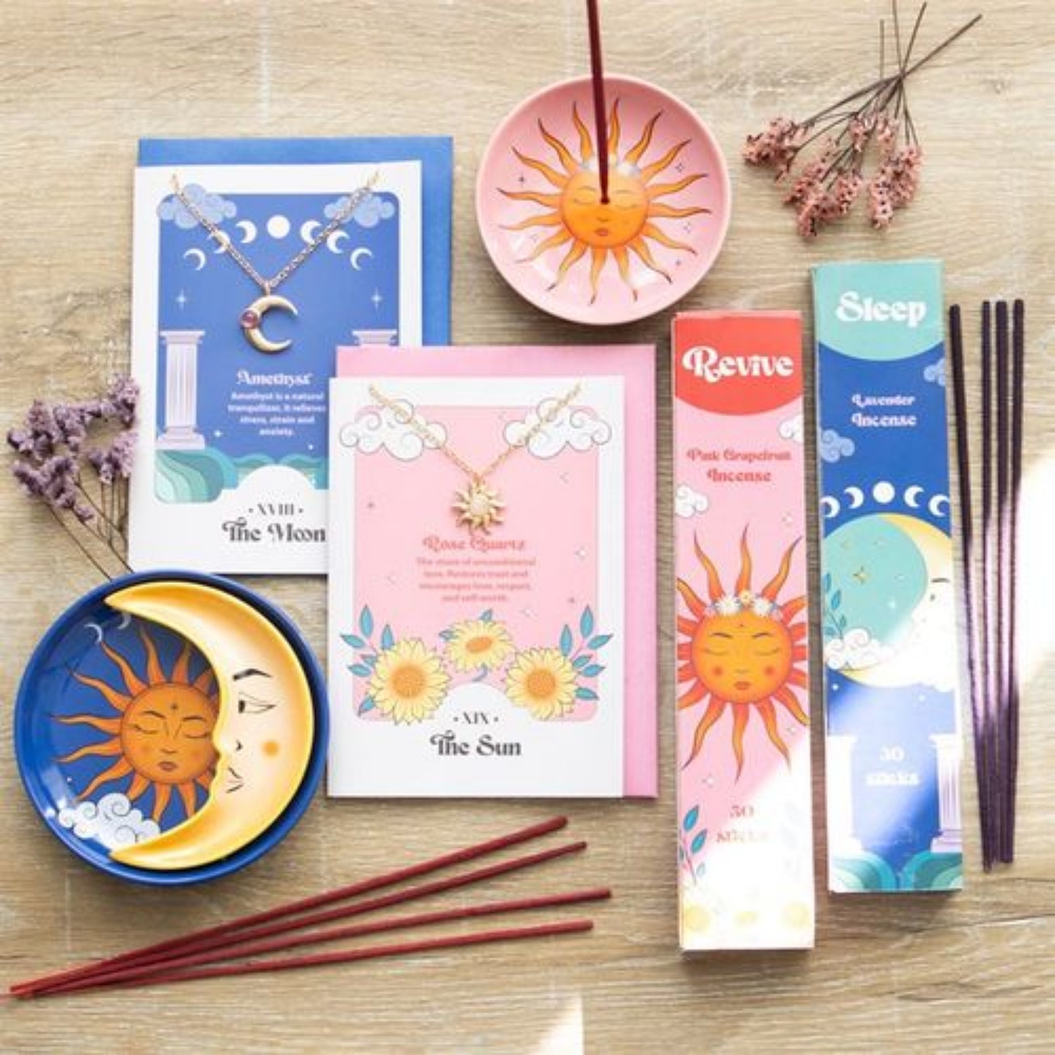 Decorative items including incense sticks, cards, and small dishes with sun and moon designs on a wooden surface.