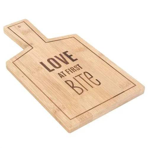 Bamboo serving board with LOVE AT FIRST BITE lettering, angled view