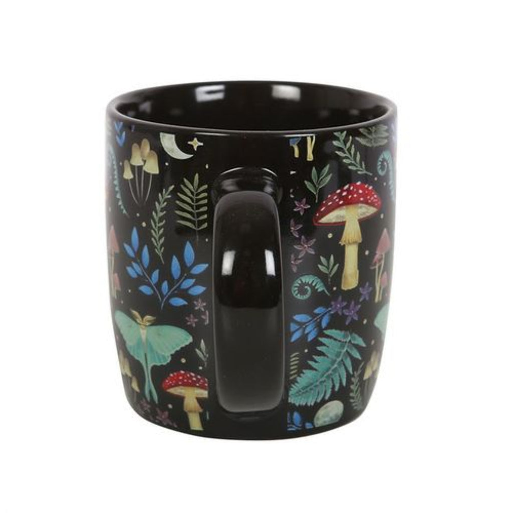 Black mug with forest-themed design featuring mushrooms and leaves on a white background