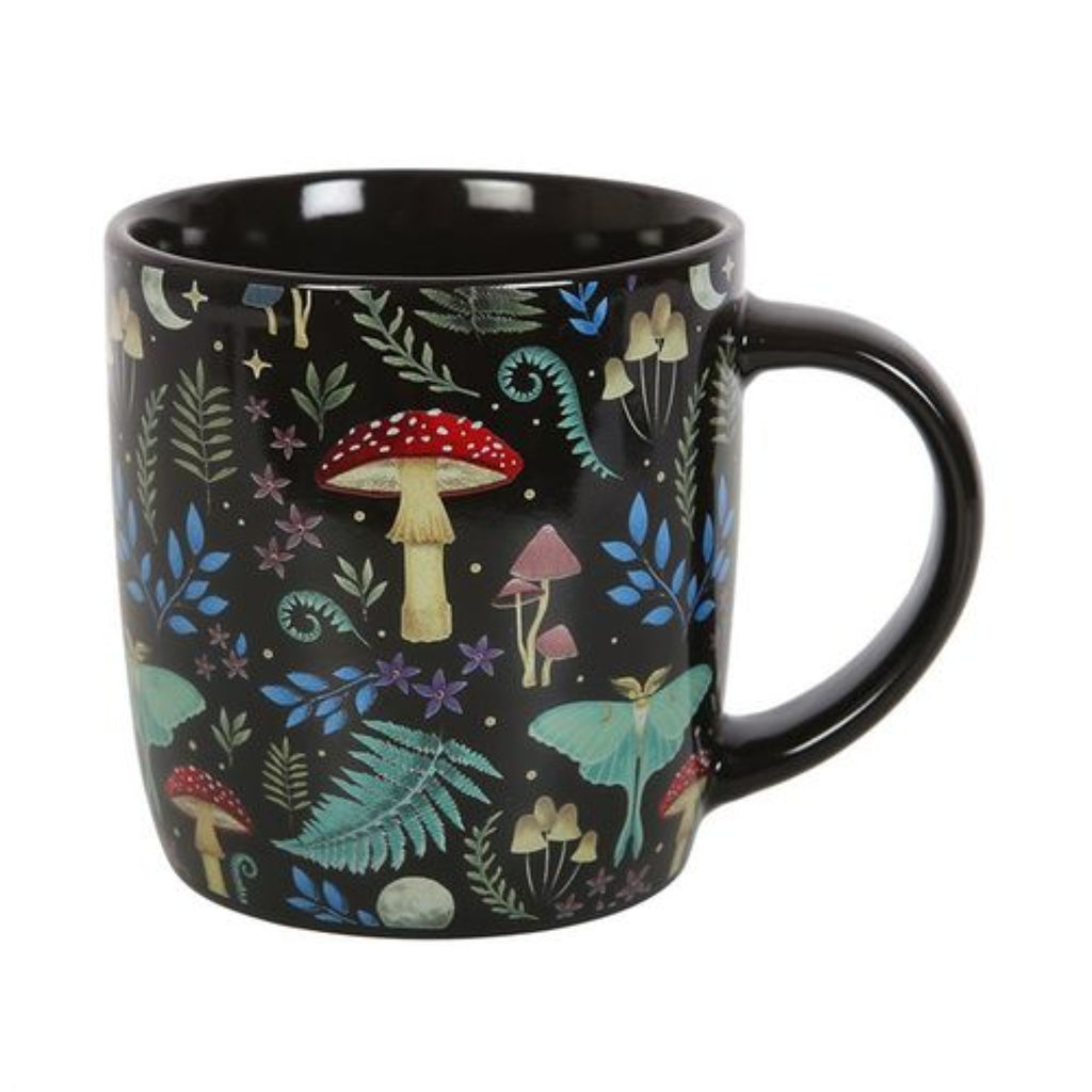 Black mug with colorful forest pattern featuring mushrooms and leaves on a white background