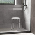 White shower stool with round seat and height-adjustable legs in shower area