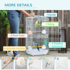 White metal bird cage with handle, swing, feeding cups, and wooden perches