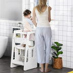 White kids step stool with toddler standing on the steps beside a countertop