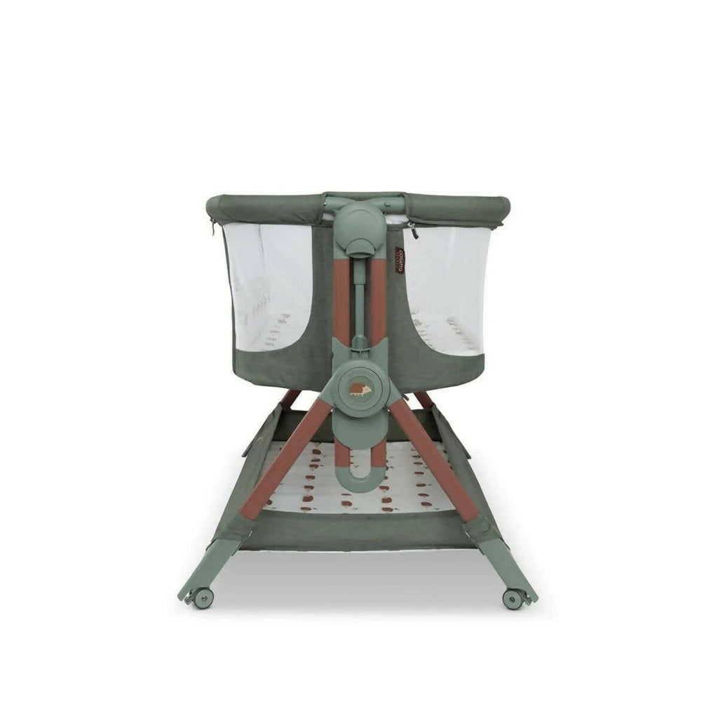 Olive folding bedside crib standing with canopy sides and patterned mattress tray