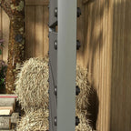 Dark grey planter box side panel with rivets, mounted against a wooden fence.