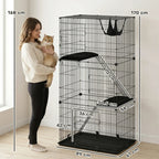 Black 3-tier cat cage with ladder and platforms, shown with a person for scale
