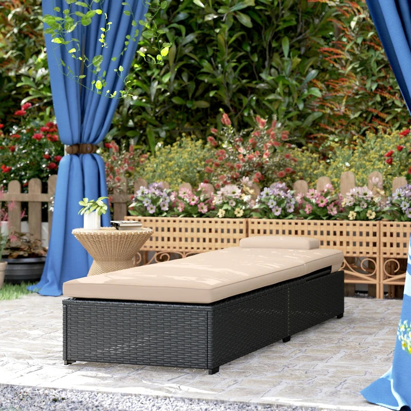 Black woven outdoor sun lounger with beige cushion on patio tiles