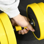 Hand gripping a black center handle between yellow weight plates on an adjustable dumbbell