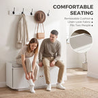 White hallway storage bench with padded seat and wall coat hooks for shoes