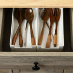 Grey cabinet drawer with wooden kitchen utensils on shelf, under rubber-wood top.