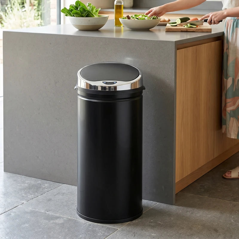 Black stainless steel motion sensor trash can beside kitchen countertop