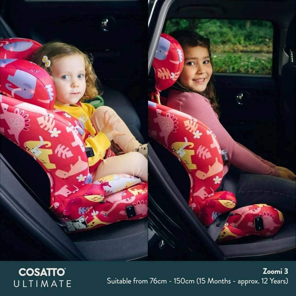Two children seated in red animal-print car seats inside a vehicle