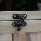 Bronze metal latch on a light wood small animal hutch door