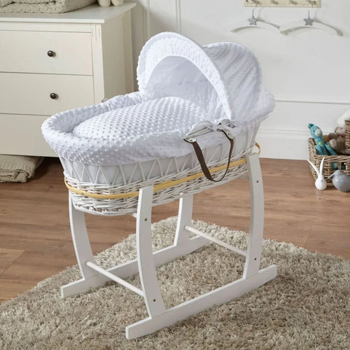 White wicker baby moses basket on rocking stand with white hooded bedding
