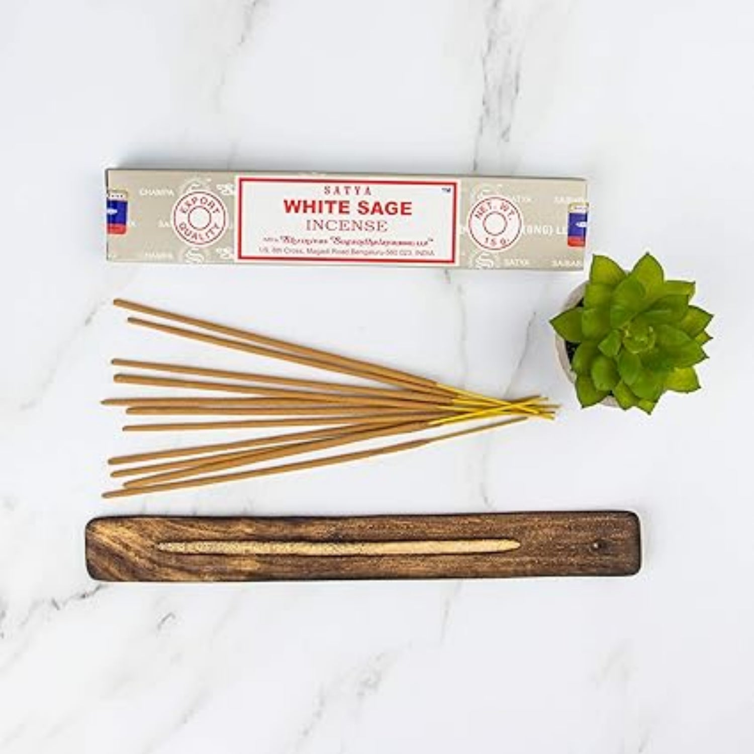 Wabi-Sabi incense sticks with packaging and a wooden incense holder on a white marble surface.