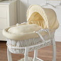 Beige wicker moses basket with padded mattress and hood cover, front tie straps