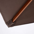 Brown umbrella canopy edge with fabric seam and wooden frame pole