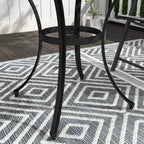 Black round table with curved legs and flat base feet under a slatted grid top