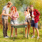Green portable charcoal BBQ grill with cooking grates during outdoor grilling