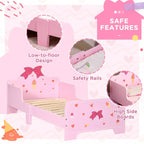 Pink toddler bed with princess bow, hearts and ice-cream patterns; low-to-floor design with safety rails