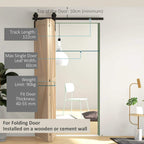 Black barn door track kit over doorway with black rail and hangers on wood frame