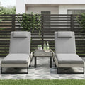 Light grey PE rattan sun lounger set with two chairs and side table on patio