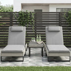 Light grey PE rattan sun lounger set with two chairs and side table on patio
