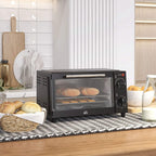 Black countertop mini oven on kitchen counter, glass door open with baked items inside.