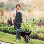 Black metal garden fence with pointed finials and swirl accents, set along a flower bed.